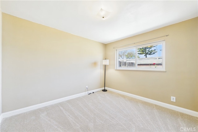 unfurnished room with carpet flooring and baseboards