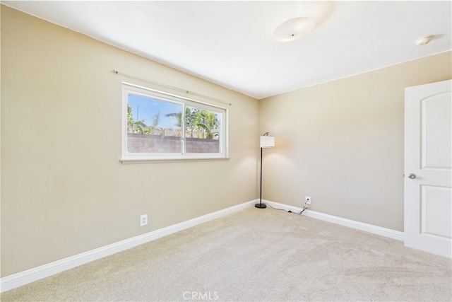 unfurnished room featuring light carpet, baseboards, and a smoke detector