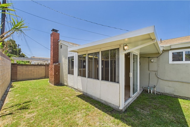 rear view of property featuring a sunroom