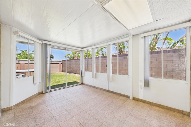 unfurnished sunroom with plenty of natural light and baseboards