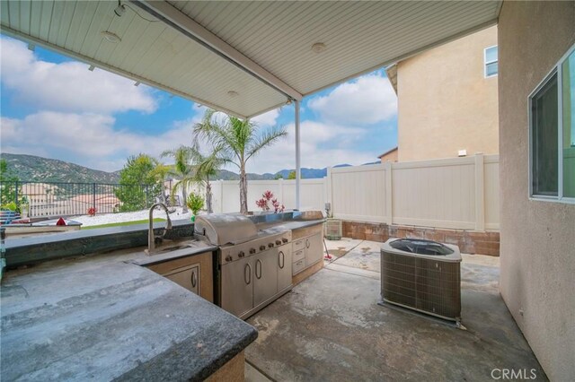 3344 Pokeroot Ln, San Bernardino, CA 92407 - fenced backyard featuring a patio, central AC, a sink, and a mountain view