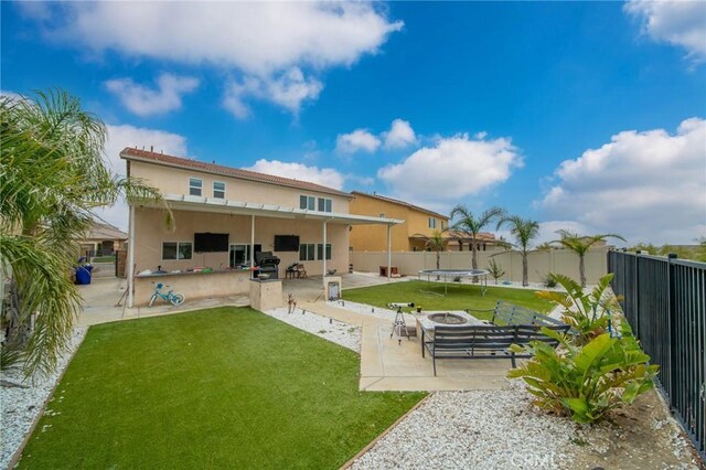 3344 Pokeroot Ln, San Bernardino, CA 92407 - back of property with a trampoline, a patio area, and stucco siding