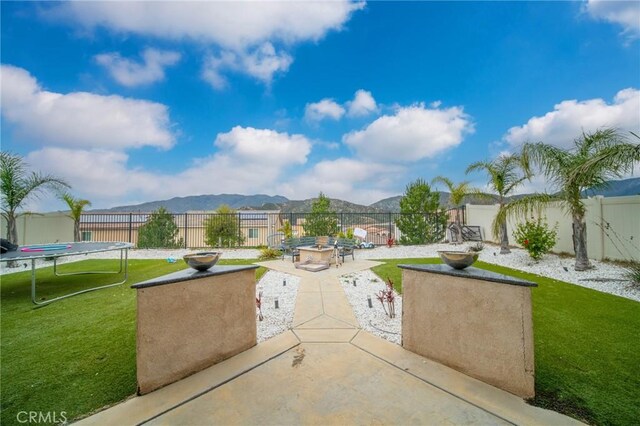 3344 Pokeroot Ln, San Bernardino, CA 92407 - view of patio with a trampoline, a mountain view, and a fire pit