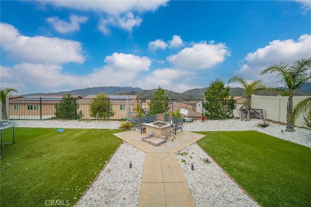 3344 Pokeroot Ln, San Bernardino, CA 92407 - view of yard with a trampoline, a patio, a fire pit, and a mountain view