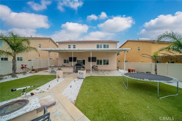 3344 Pokeroot Ln, San Bernardino, CA 92407 - rear view of house featuring a trampoline, stucco siding, and a patio area