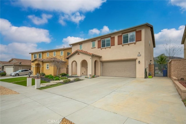 3344 Pokeroot Ln, San Bernardino, CA 92407 - mediterranean / spanish house featuring a garage, stucco siding, concrete driveway, and a gate