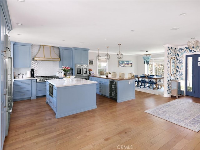 6443 W 81st St, Los Angeles, CA 90045 - kitchen featuring custom range hood, a center island, wine cooler, appliances with stainless steel finishes, and backsplash
