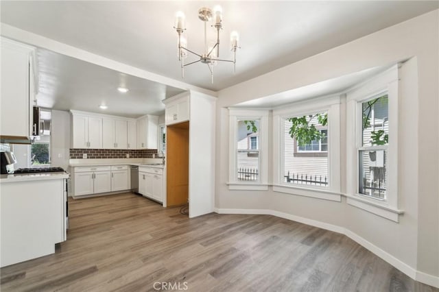kitchen with stainless steel appliances, a chandelier, plenty of natural light, and white cabinets