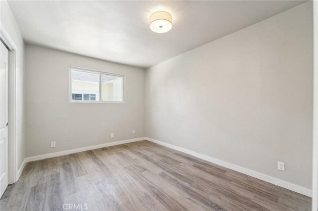 empty room with light wood-style floors and baseboards