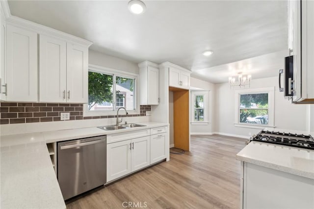 kitchen featuring appliances with stainless steel finishes, a sink, white cabinets, tasteful backsplash, and recessed lighting