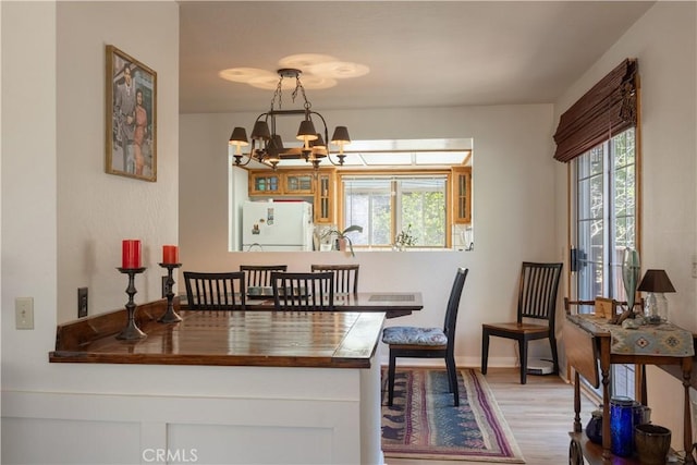 919 S Waldstrasse Way, Big Bear Lake, CA 92314 - dining area featuring a chandelier, wood finished floors, and baseboards