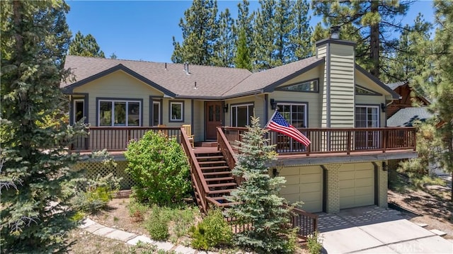 919 S Waldstrasse Way, Big Bear Lake, CA 92314 - view of front of property featuring a wooden deck, a chimney, driveway, roof with shingles, and a garage