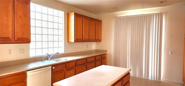 8281 Triplett Ln, Hemet, CA 92545 - kitchen with white dishwasher, a sink, brown cabinetry, and light countertops