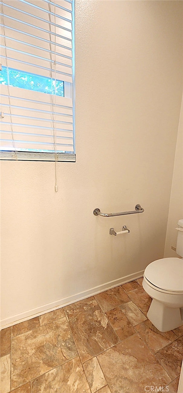 8281 Triplett Ln, Hemet, CA 92545 - bathroom featuring stone tile flooring, toilet, and baseboards