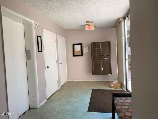 1810 Ramona Ave Unit 15, South Pasadena, CA 91030 - corridor with a textured ceiling, mail area, elevator, and tile patterned flooring