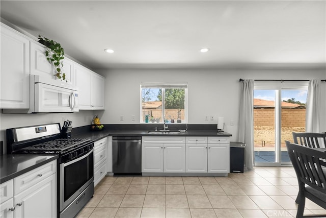 1021 Cambridge Ct, Lancaster, CA 93535 - kitchen featuring appliances with stainless steel finishes, dark countertops, recessed lighting, white cabinetry, and light tile patterned floors