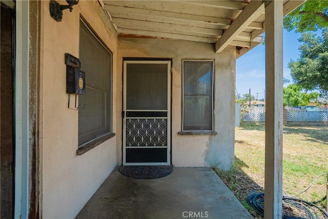 entrance to property featuring stucco siding