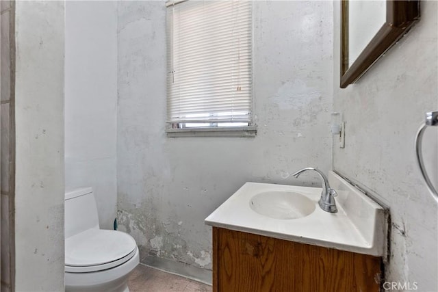 half bath featuring vanity and toilet