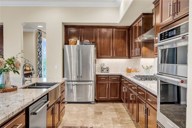 kitchen featuring appliances with stainless steel finishes, ornamental molding, a sink, light stone countertops, and ventilation hood