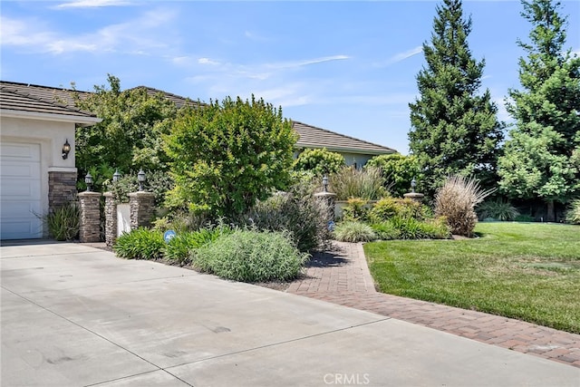 view of front of house featuring a front yard, a tiled roof, stucco siding, and a garage