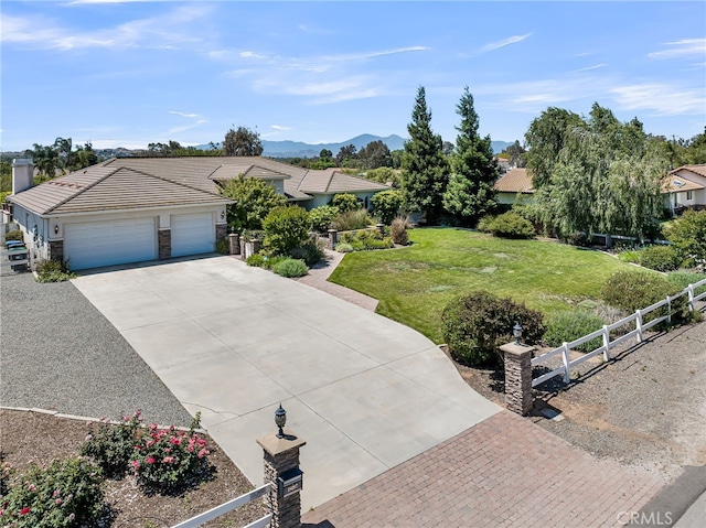 view of front of property with driveway, an attached garage, a tiled roof, and a mountain view