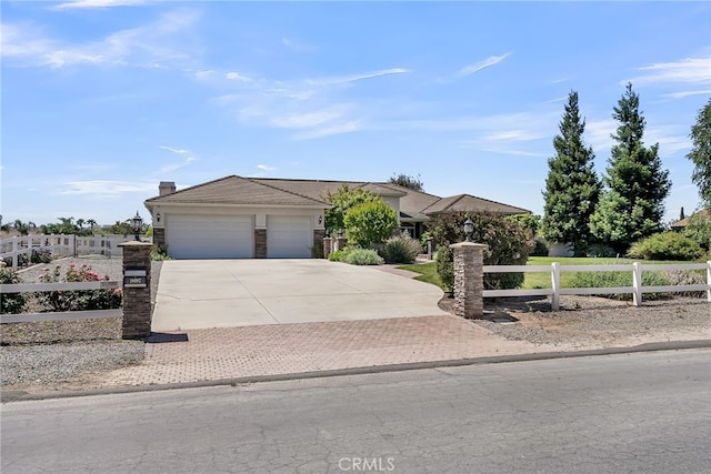 view of front facade featuring driveway, a garage, and a tiled roof