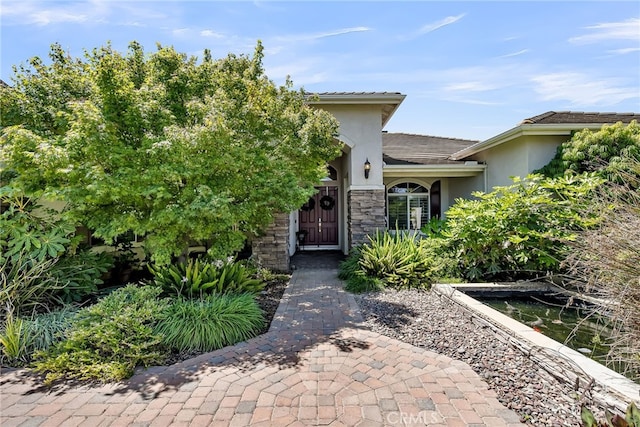 view of front of house featuring stucco siding and stone siding