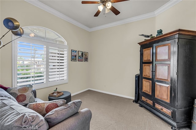 sitting room with carpet flooring, ceiling fan, crown molding, and baseboards