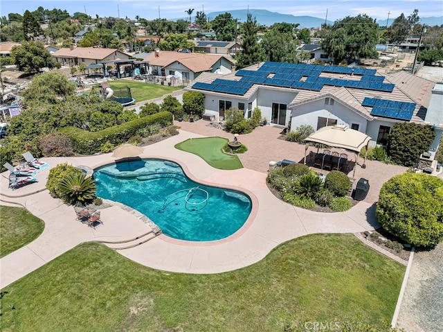 outdoor pool with a gazebo, a yard, a residential view, and a patio area