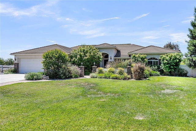 view of front of house with concrete driveway, stucco siding, a front yard, and a garage