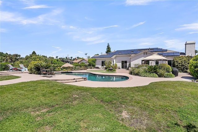 outdoor pool featuring a patio area and a lawn