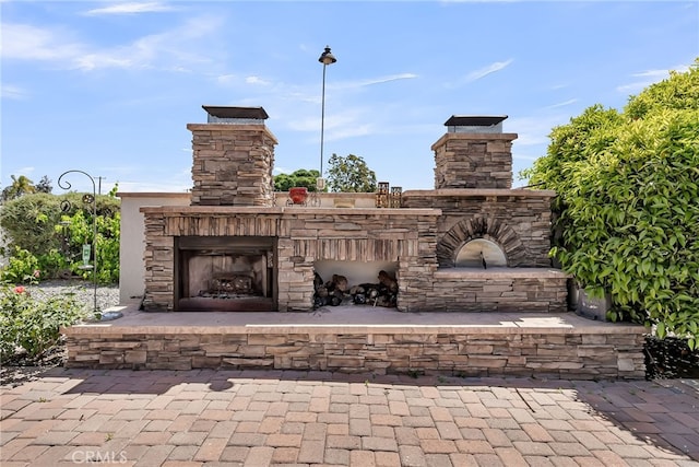 view of patio featuring an outdoor stone fireplace