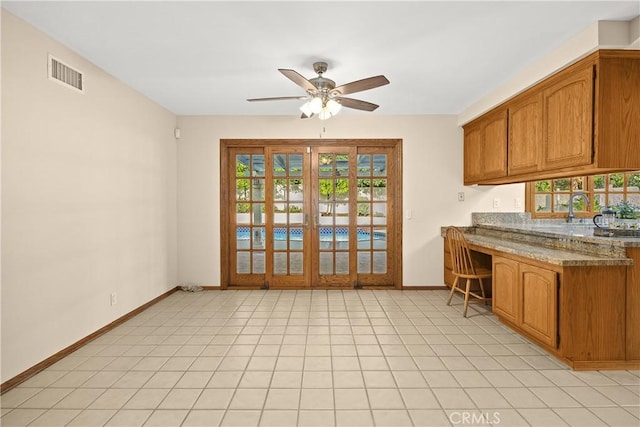 2148 Aquinas Ave, Claremont, CA 91711 - kitchen featuring ceiling fan, baseboards, brown cabinets, a sink, and a kitchen bar