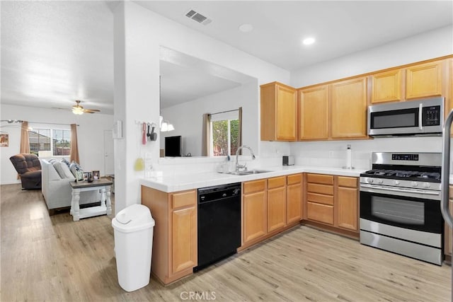 16702 Hastings Pl, Victorville, CA 92395 - kitchen featuring appliances with stainless steel finishes, a sink, light wood finished floors, open floor plan, and recessed lighting