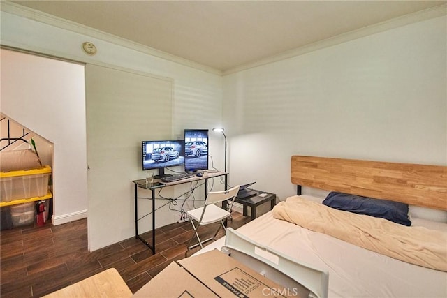 bedroom featuring ornamental molding, wood tiled floors, and baseboards