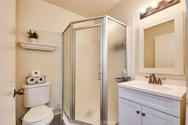 bathroom featuring a stall shower, vanity, and toilet