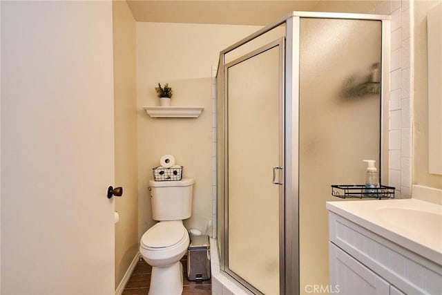 full bathroom with a shower stall, toilet, vanity, and baseboards