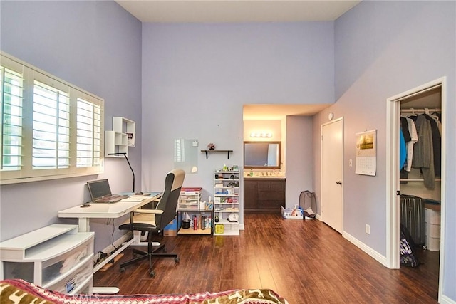 office area with a high ceiling, wood finished floors, and baseboards
