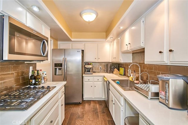 kitchen featuring stainless steel appliances, a sink, light countertops, and white cabinets