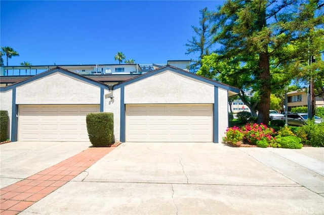 single story home with concrete driveway, stucco siding, and an attached garage