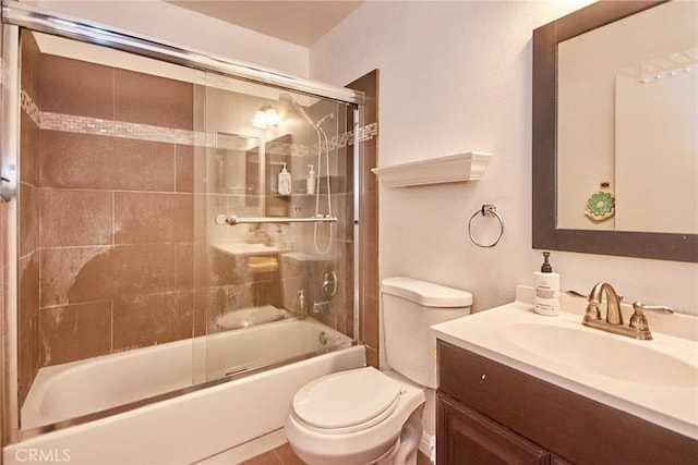 bathroom with toilet, vanity, and shower / bath combination with glass door