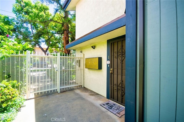 entrance to property with a gate and stucco siding