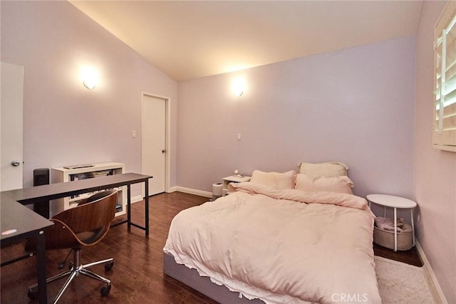 bedroom with vaulted ceiling, dark wood-style floors, and baseboards