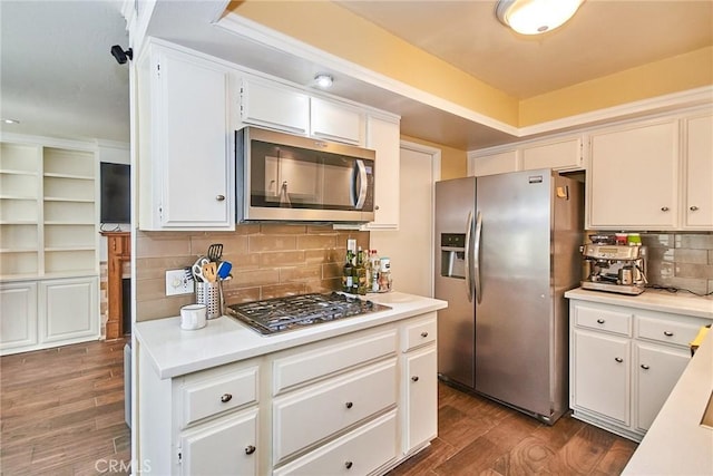 kitchen featuring appliances with stainless steel finishes, backsplash, dark wood-style floors, light countertops, and white cabinetry