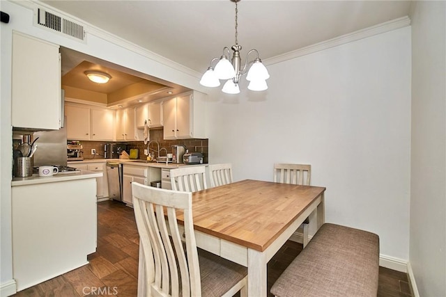 dining area featuring a chandelier, ornamental molding, and baseboards