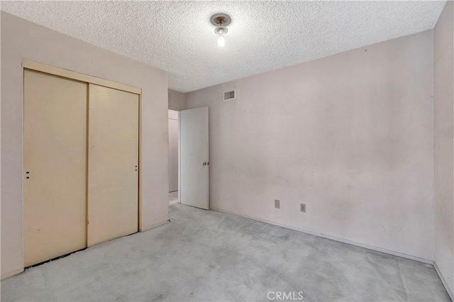 unfurnished bedroom featuring carpet flooring, a closet, and a textured ceiling