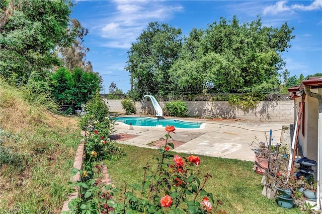 view of swimming pool with a water slide, a fenced backyard, and a patio