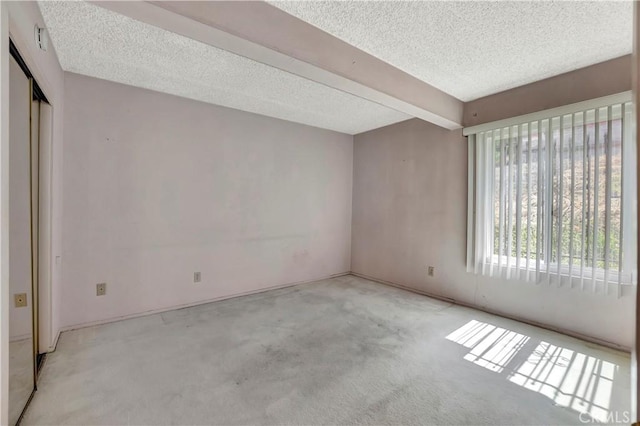 carpeted spare room with a textured ceiling