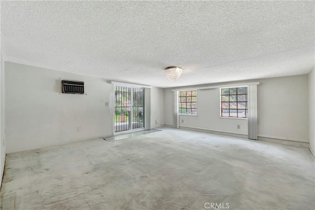carpeted spare room featuring a textured ceiling and a wall mounted AC