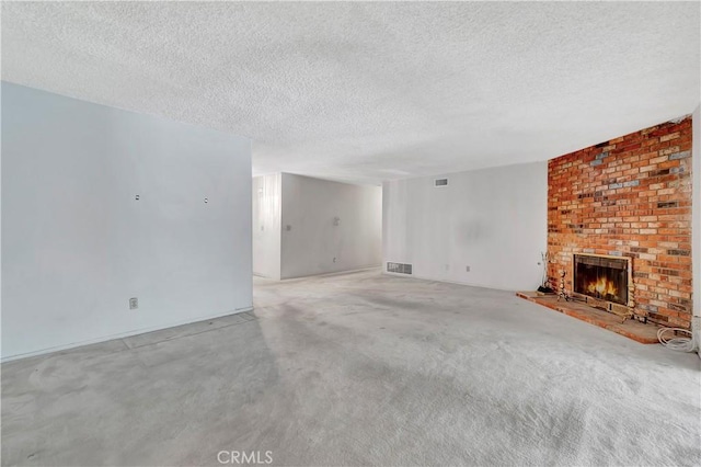 unfurnished living room with a textured ceiling and a brick fireplace